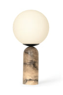 Table lamp with a spherical cream shade and a marble-textured base on a white background
