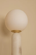 Modern wall lamp with spherical shade on a beige background