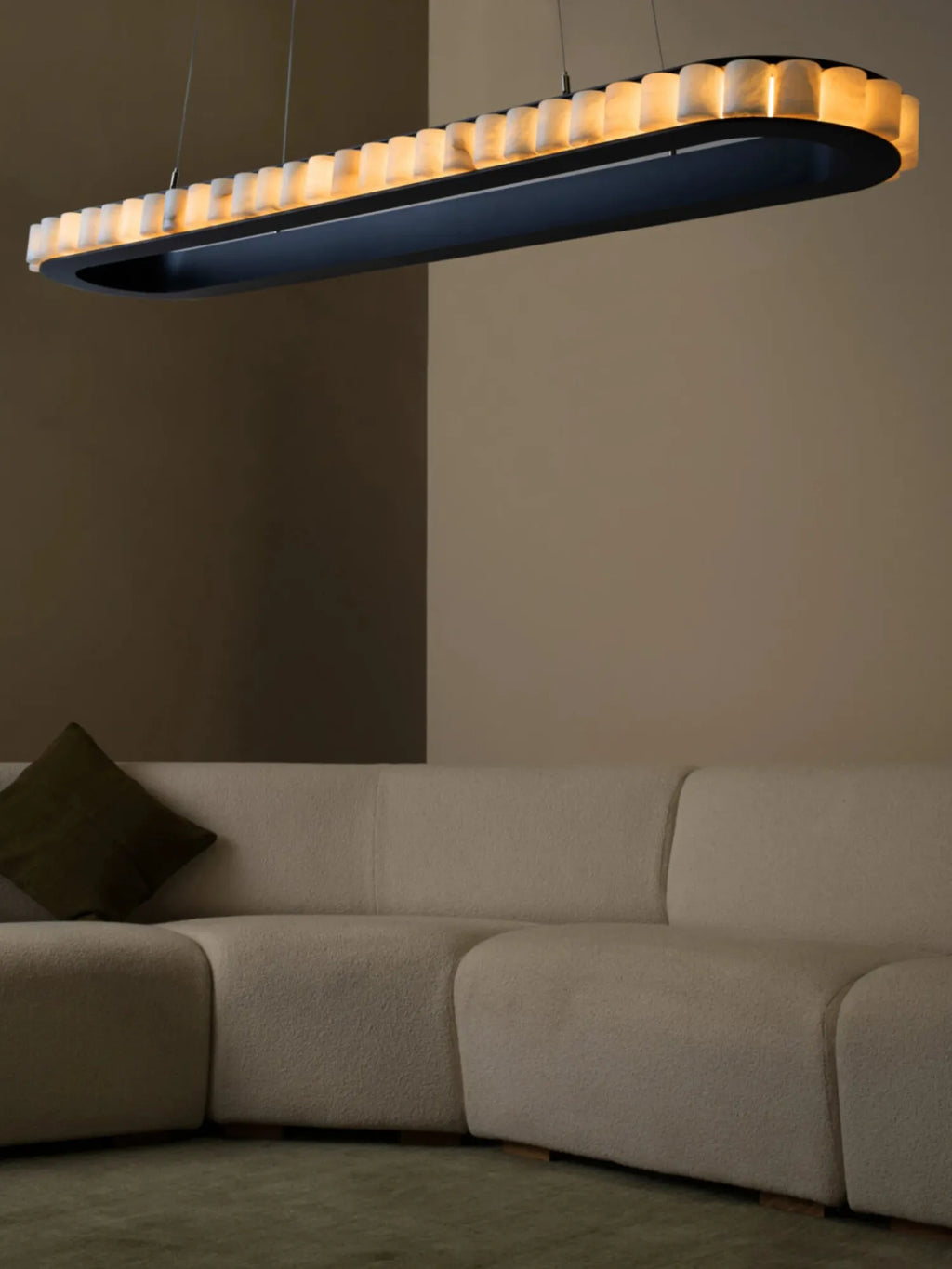 CTO Lighting Avalon Oval Pendant Light, a luxurious contemporary ceiling light featuring an elongated matte black metal frame adorned with individual translucent alabaster shades that emit a warm, soft glow. This elegant alabaster pendant light is perfect for modern dining rooms, luxury living spaces, or organic modern interiors seeking a sophisticated statement lighting fixture.