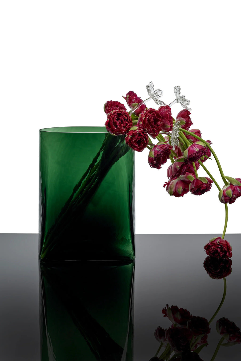 Serax Josephine Vase with Glass Tube 03, a tall, rectangular emerald green glass vase with a sleek, minimalist design, shown holding deep red fringed tulips and delicate clear glass butterfly stems. This elegant decorative vase is perfect for adding a touch of modern sophistication to any home or office space.