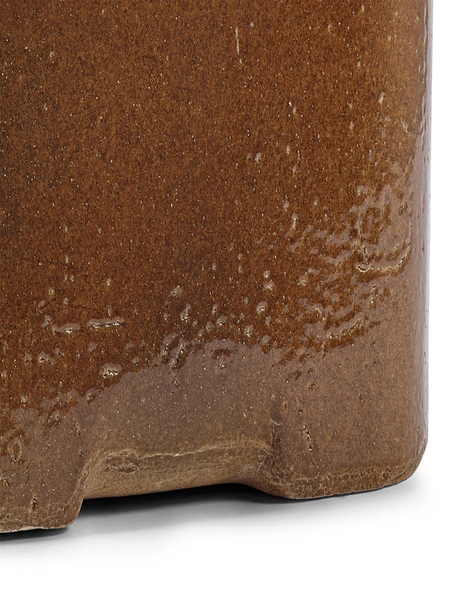 Close-up of a brown ceramic pot with textured surface on a white background