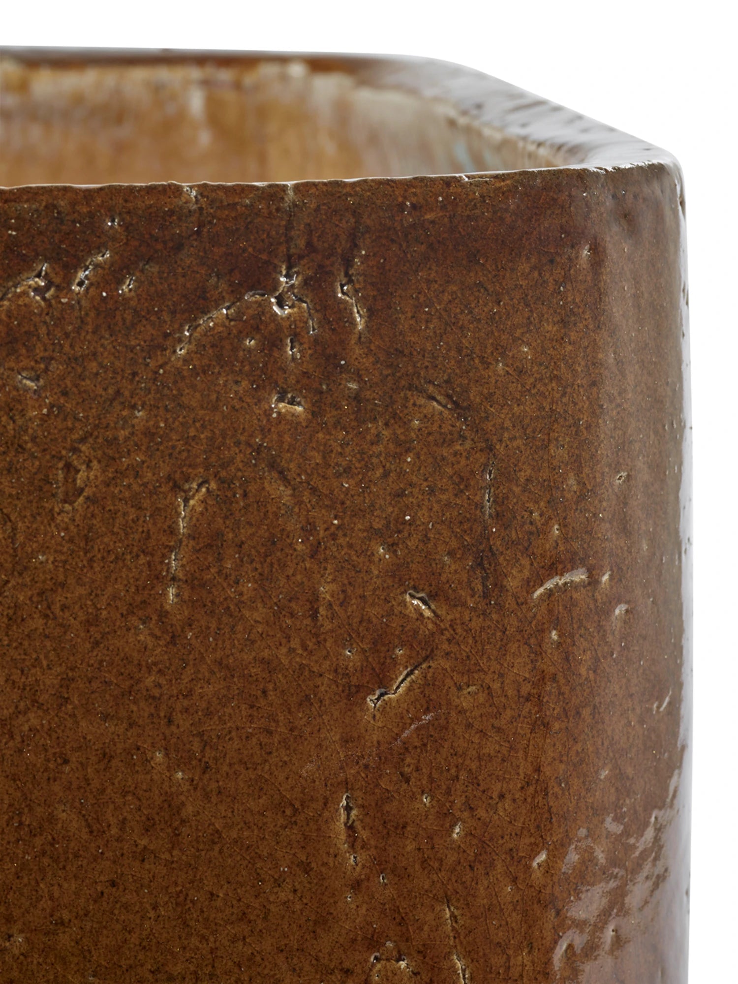 Close-up of a brown ceramic planter with textured surface
