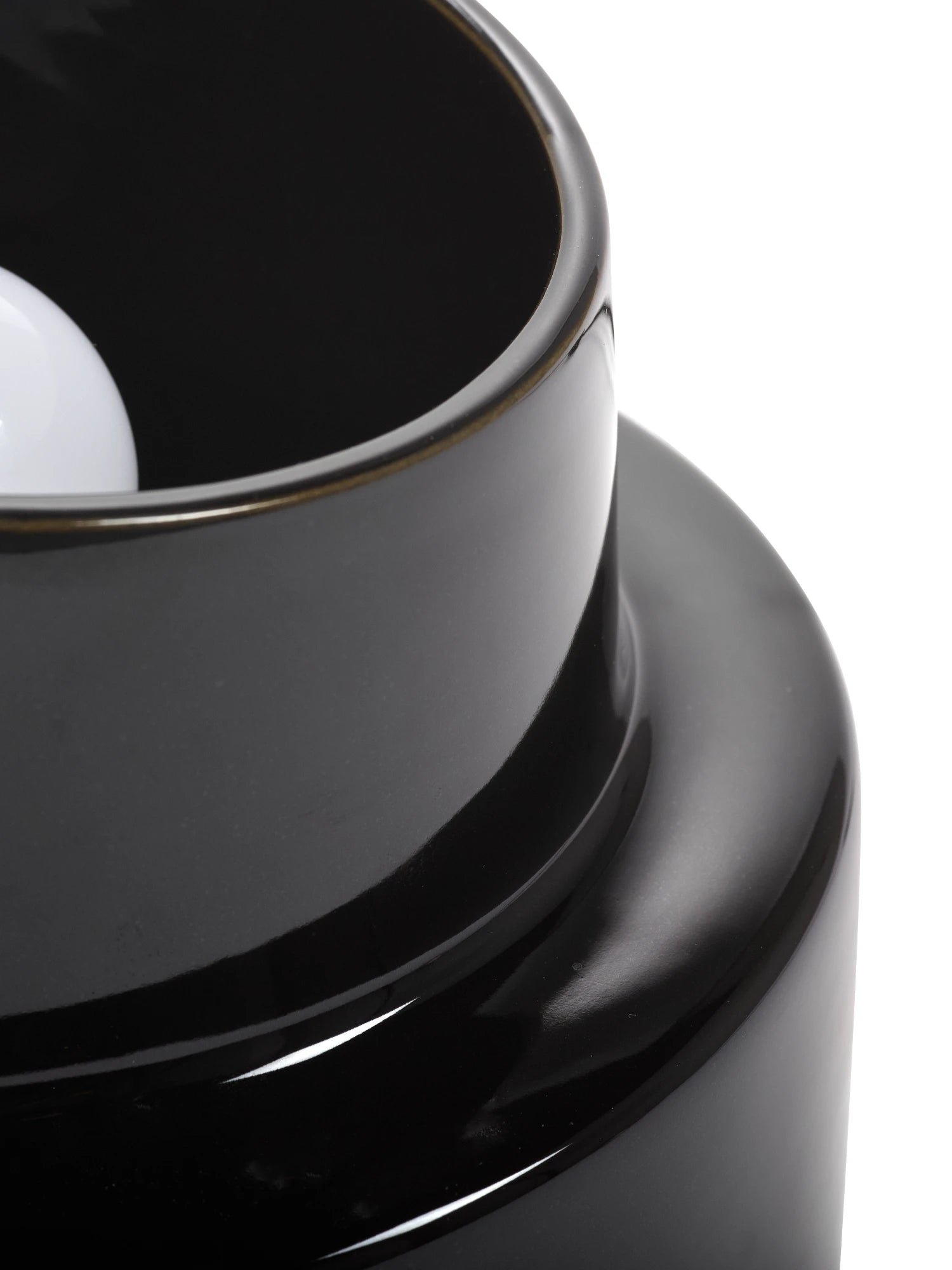 Close-up of a black ceramic product with a white interior