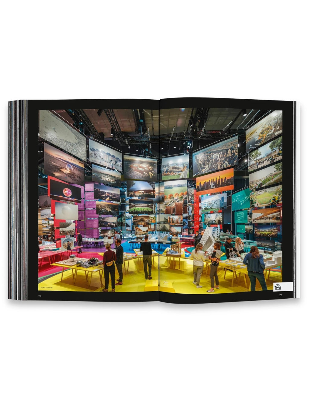 Book BIG – Formgiving, featuring a vibrant, double-page spread showcasing an architectural exhibition with large screens displaying diverse projects and people interacting with models on colorful tables. This premium architecture book is perfect for design students and professionals seeking inspiration and insights into innovative form-giving concepts.