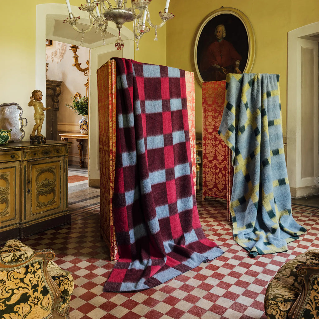 Layered Dancing Doll Oversized Throw Blanket in a vibrant red, burgundy, and light blue checkerboard pattern, draped over a decorative screen. This luxurious, soft throw blanket offers stylish comf...