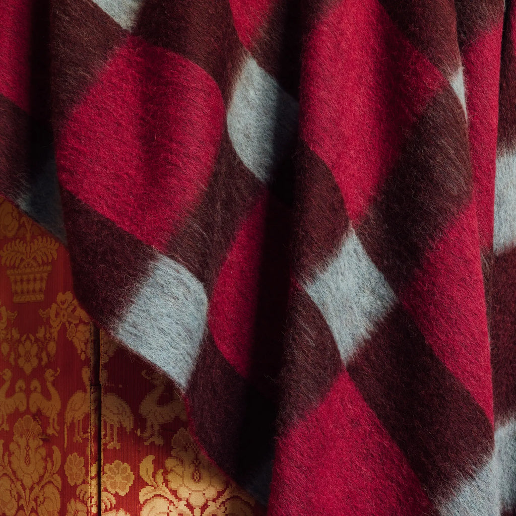 Layered Dancing Doll Oversized Throw Blanket, featuring a soft, fuzzy texture with a bold red, maroon, and light blue argyle pattern. Perfect for adding warmth and a pop of color to any living space.