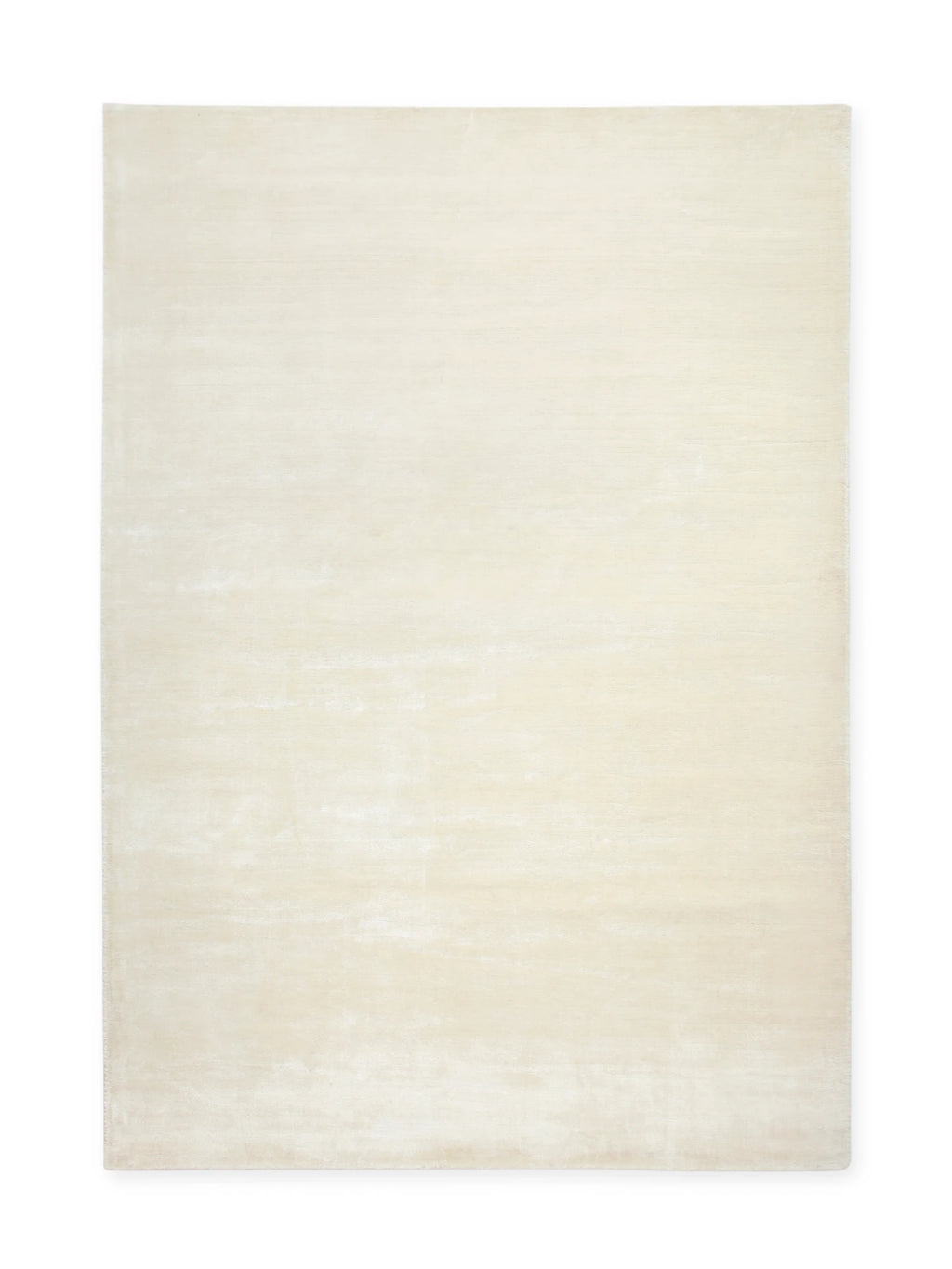 Tinted Objects Backfjall Viscose Rug, a rectangular, plush cream-colored area rug with a subtle sheen and varied texture, giving it a luxurious, hand-knotted appearance. This elegant floor covering provides a soft foundation for modern living rooms or bedrooms, ideal for homeowners seeking a sophisticated and comfortable accent.