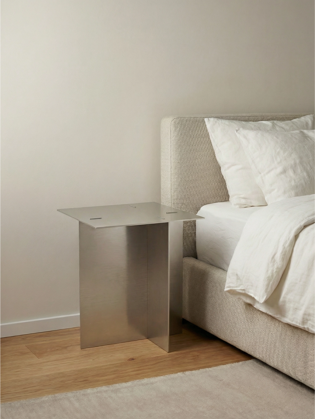 TCL Studios Bauhaus Side Table, a sleek modern minimalist side table crafted from brushed metal with a subtle silver-grey finish and a distinctive geometric, folded design. This industrial chic accent table features a clean-lined rectangular top supported by two vertical panels, embodying the Bauhaus aesthetic. Perfect as a contemporary metal bedside table or a minimalist living room end table for design-forward interiors.