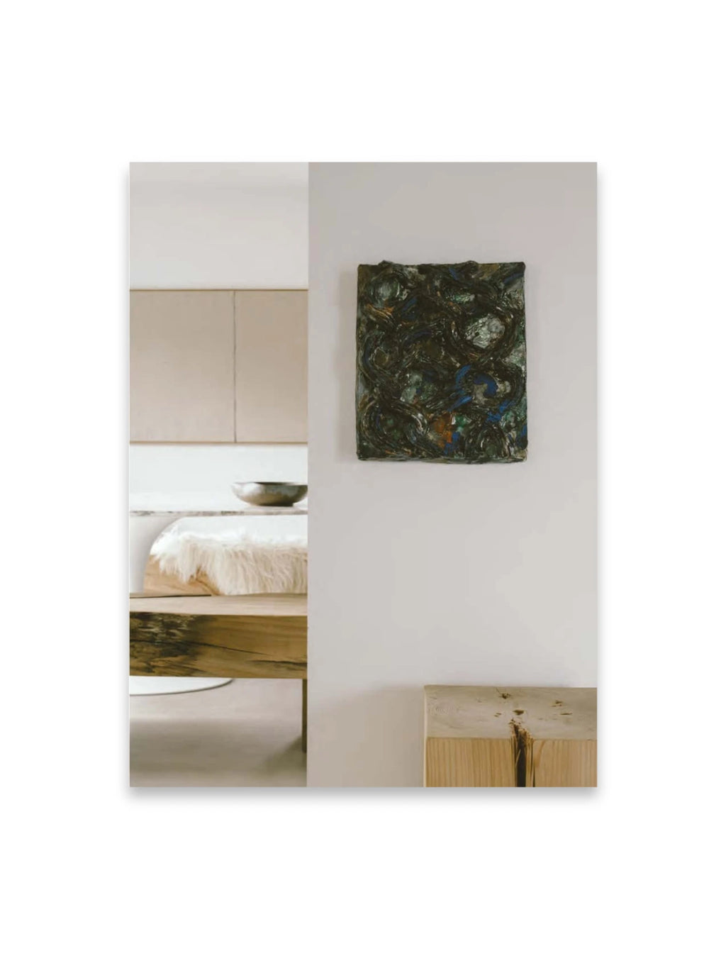 Book Bea Mombaers – items & interiors, a lifestyle photography book showcasing a modern interior with an abstract dark green and blue textured art piece on a white wall, above a light natural wood bench with a prominent crack. This inspiring interior design book is perfect for decor enthusiasts and those seeking home styling ideas.
