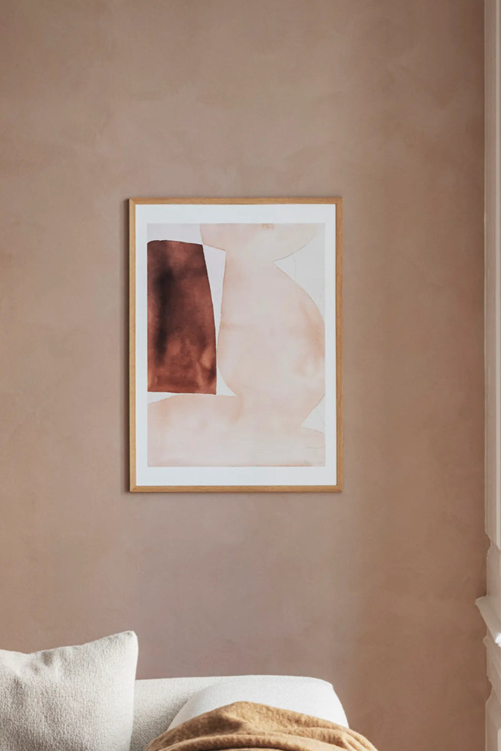 The Poster Club Bloom, an abstract art print featuring organic, fluid shapes in warm brown and soft blush beige tones, framed in natural oak with a crisp white mat. This minimalist wall art is perfect for adding a touch of contemporary elegance to living rooms, Japandi bedrooms, or organic modern gallery walls.