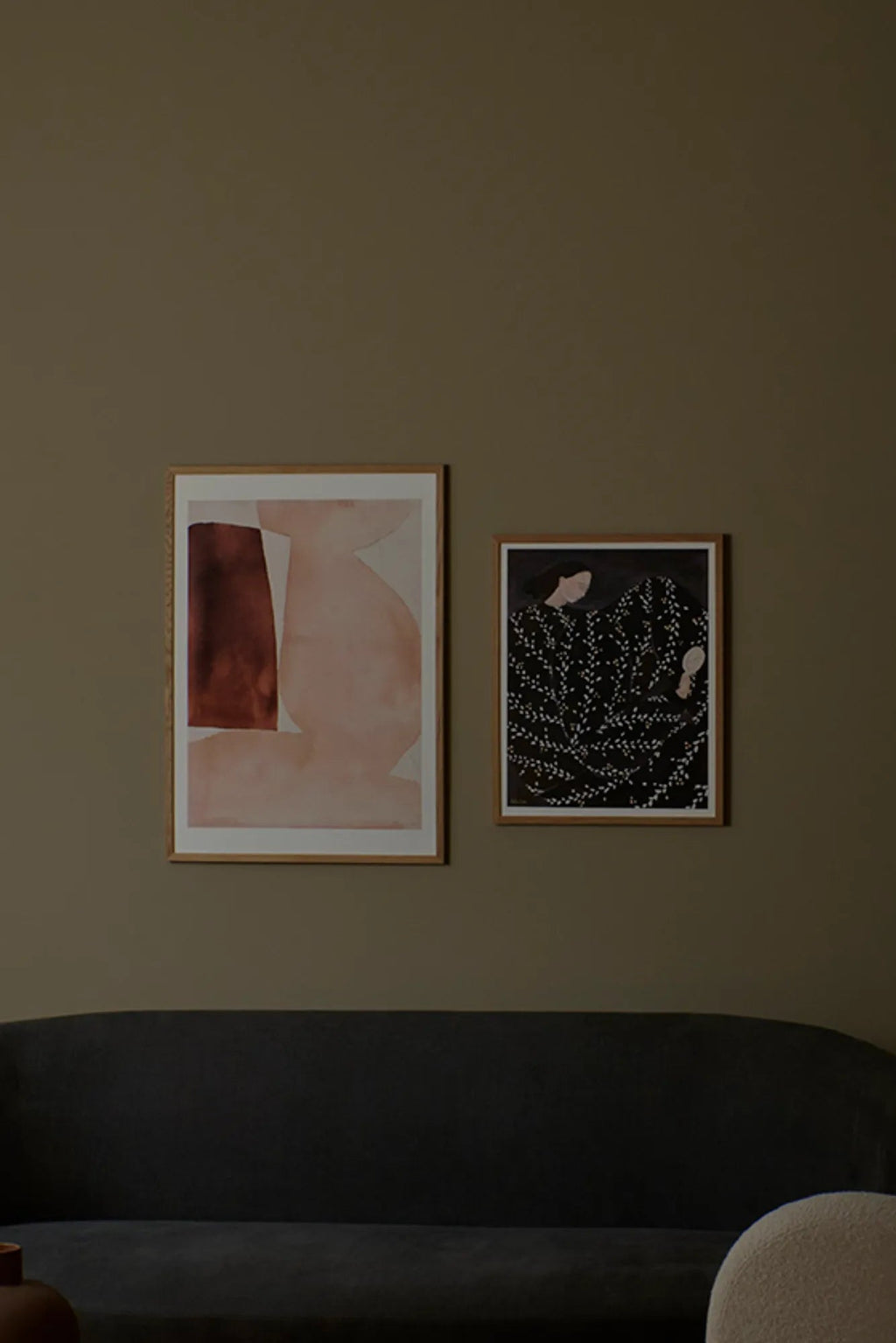 The Poster Club Bloom, a contemporary abstract art print featuring soft organic shapes in muted blush pink and a contrasting rich reddish-brown block, set against a light background and framed in natural oak.