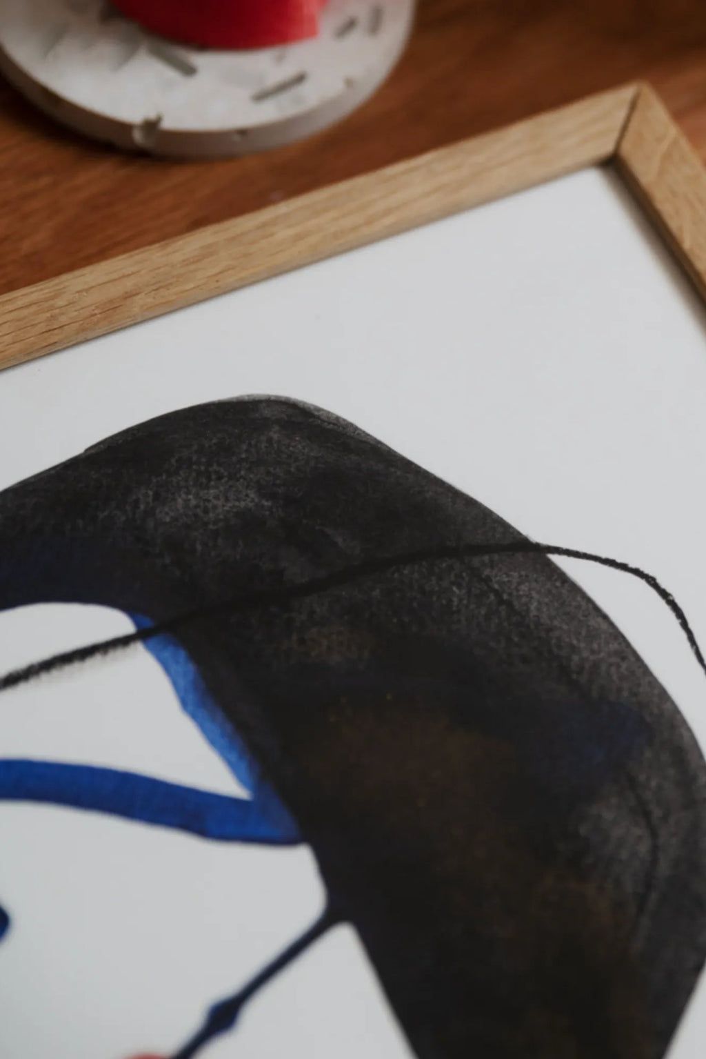 The Poster Club Link, a contemporary abstract art print featuring bold, organic black shapes with textured brushstrokes and vibrant royal blue accents, set against a clean white background. It is elegantly presented in a light natural oak frame with a crisp white mat. Perfect as modern wall art for a minimalist living room, Scandinavian bedroom, or sophisticated gallery wall.