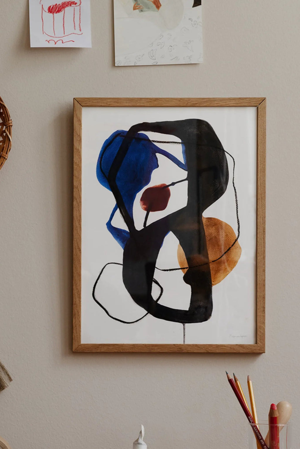 The Poster Club Link, an abstract art print featuring bold, organic shapes in deep black, rich blue, and warm ochre with a subtle dark red accent, set against a crisp white background. This contemporary poster, framed in light natural oak, showcases expressive brushstrokes and fluid lines, perfect for modern minimalist living rooms, Scandinavian bedrooms, or as a striking addition to a gallery wall.