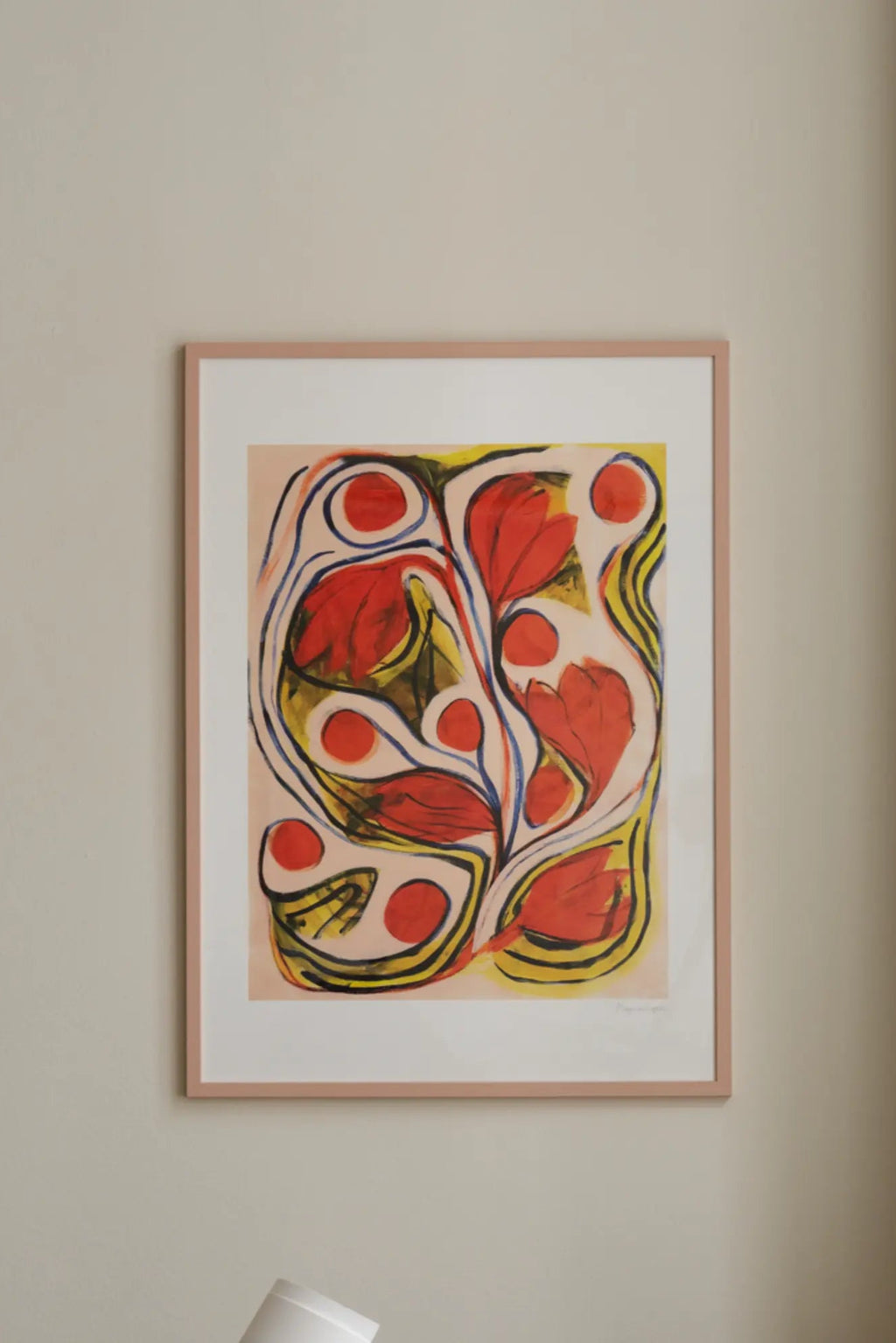The Poster Club Summertime, a vibrant abstract floral art print featuring bold red organic shapes resembling flowers and berries, accented by energetic yellow and deep blue lines, all set against a soft peach background. This colorful poster is presented with a crisp white mat and a modern light pink frame, perfect as contemporary wall art for a lively living room, bedroom, or gallery wall in organic modern and expressive interiors.