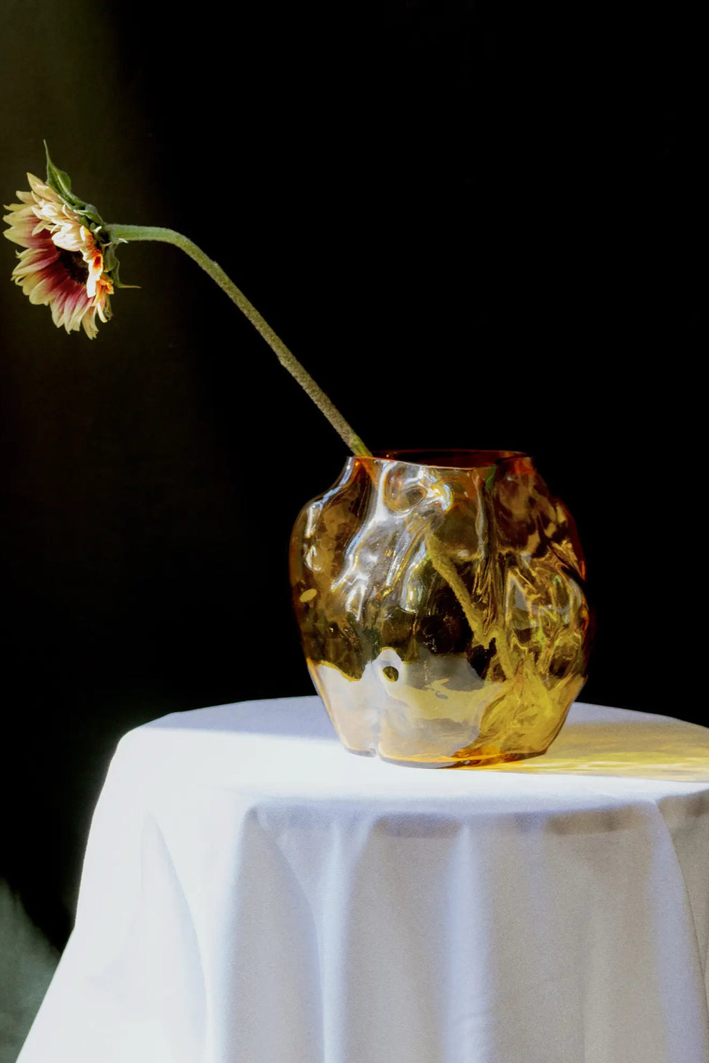 A large, white ceramic vase with a unique, textured design