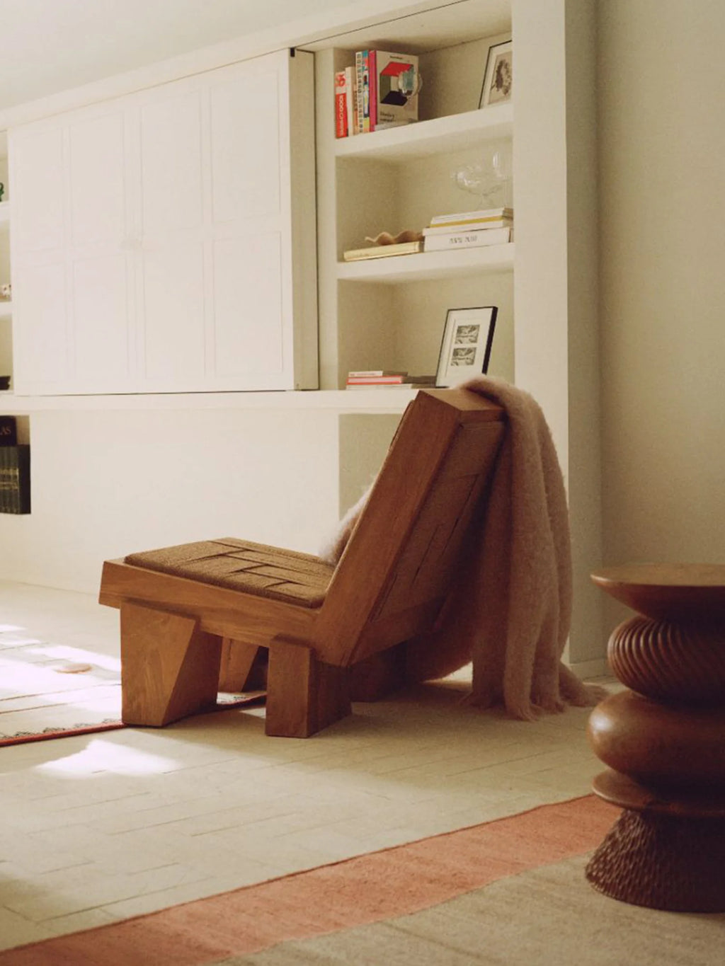 Heaps & Woods Block Lounge Chair, a striking brutalist solid wood lounge chair with a warm natural tone and distinct geometric, block-like silhouette, featuring a woven natural fiber seat cushion.