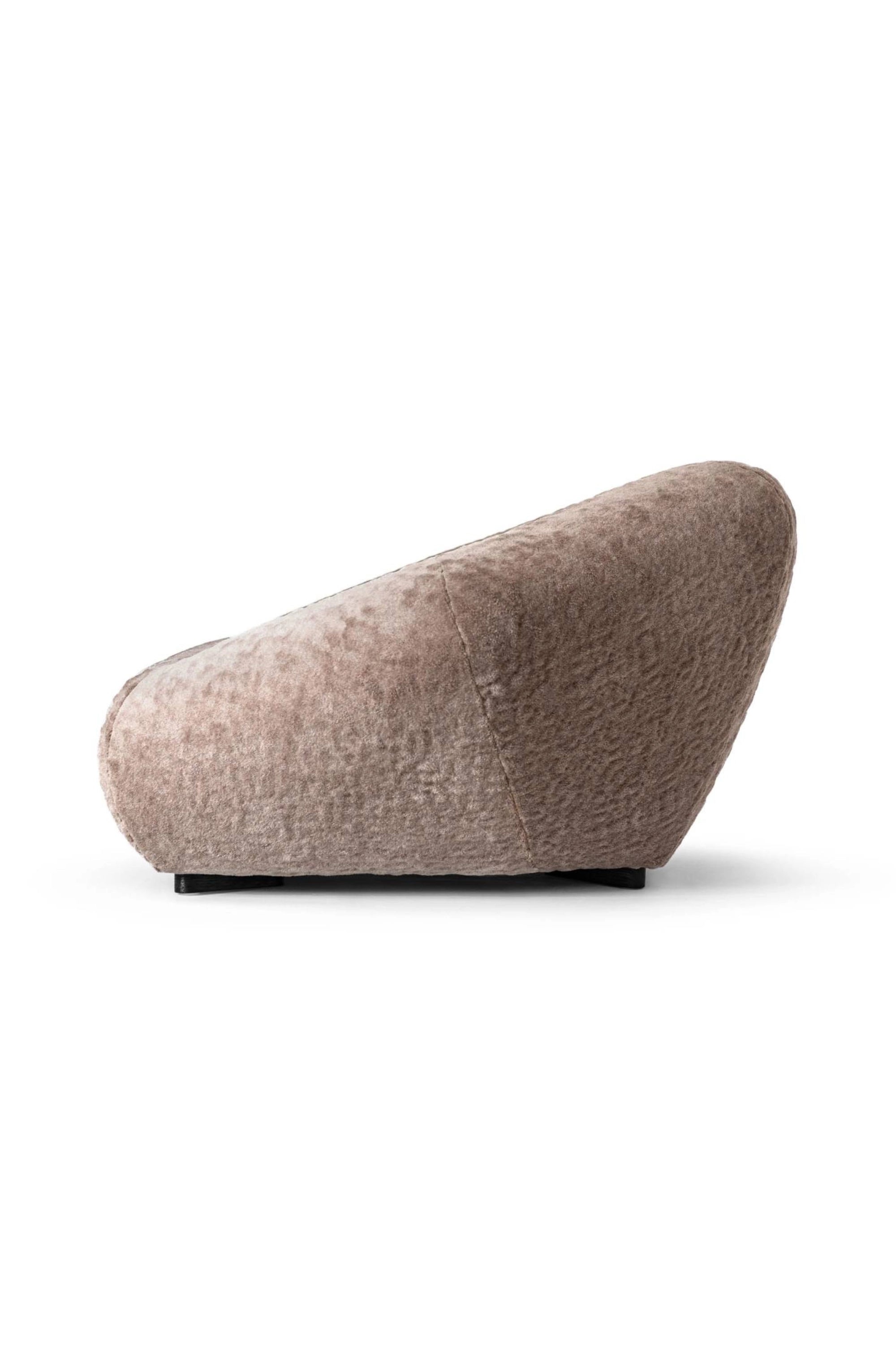 Hessentia Bloom Armchair, a sophisticated low-profile lounge chair upholstered in luxurious warm taupe bouclé fabric, featuring a unique organic sculptural silhouette with plush, inviting curves.