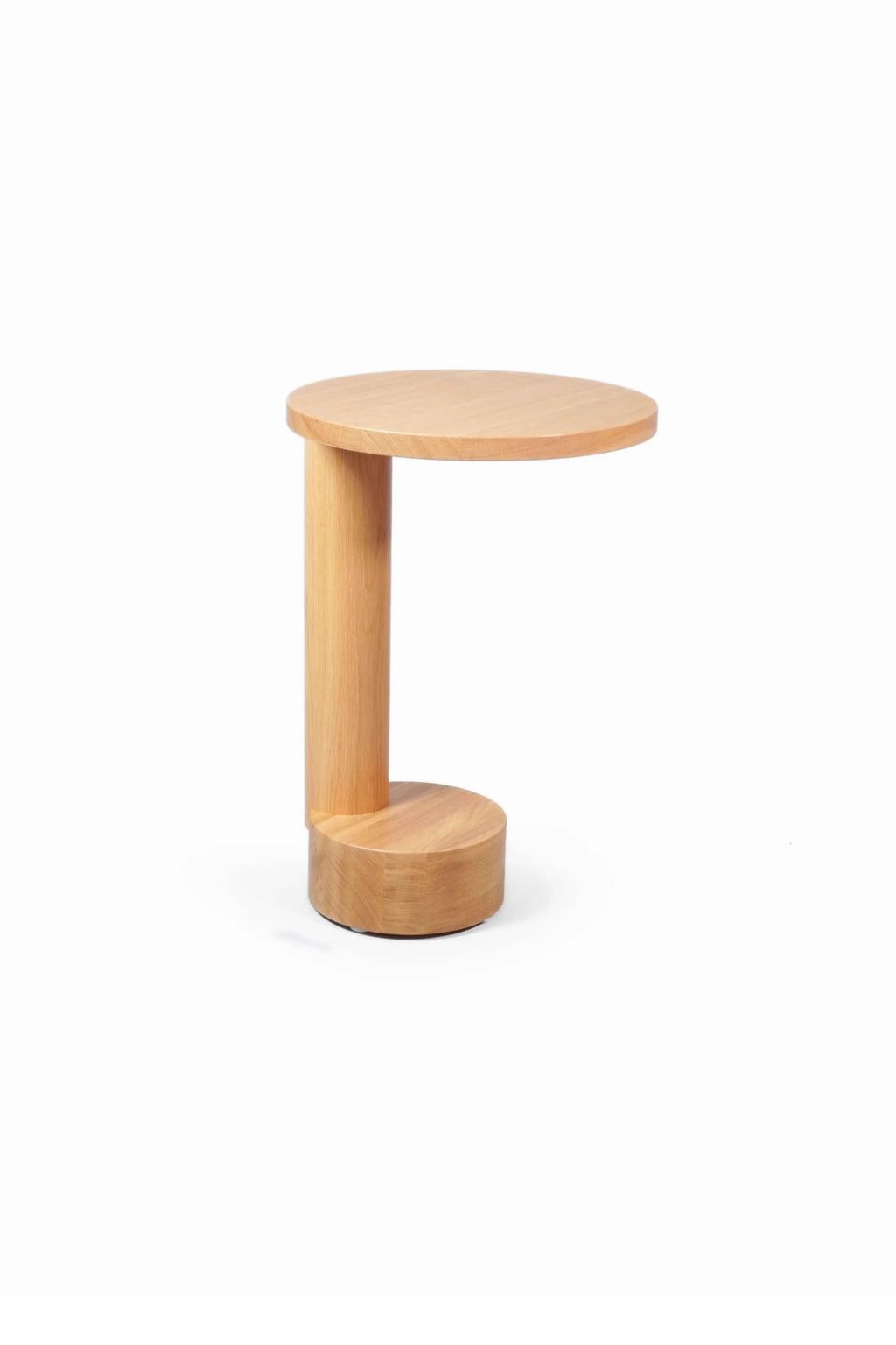 TAMO Bold Side Table, a unique C-shaped modern natural oak wood accent table with a cylindrical base and column, captured in a studio shot. Perfect for contemporary interiors.