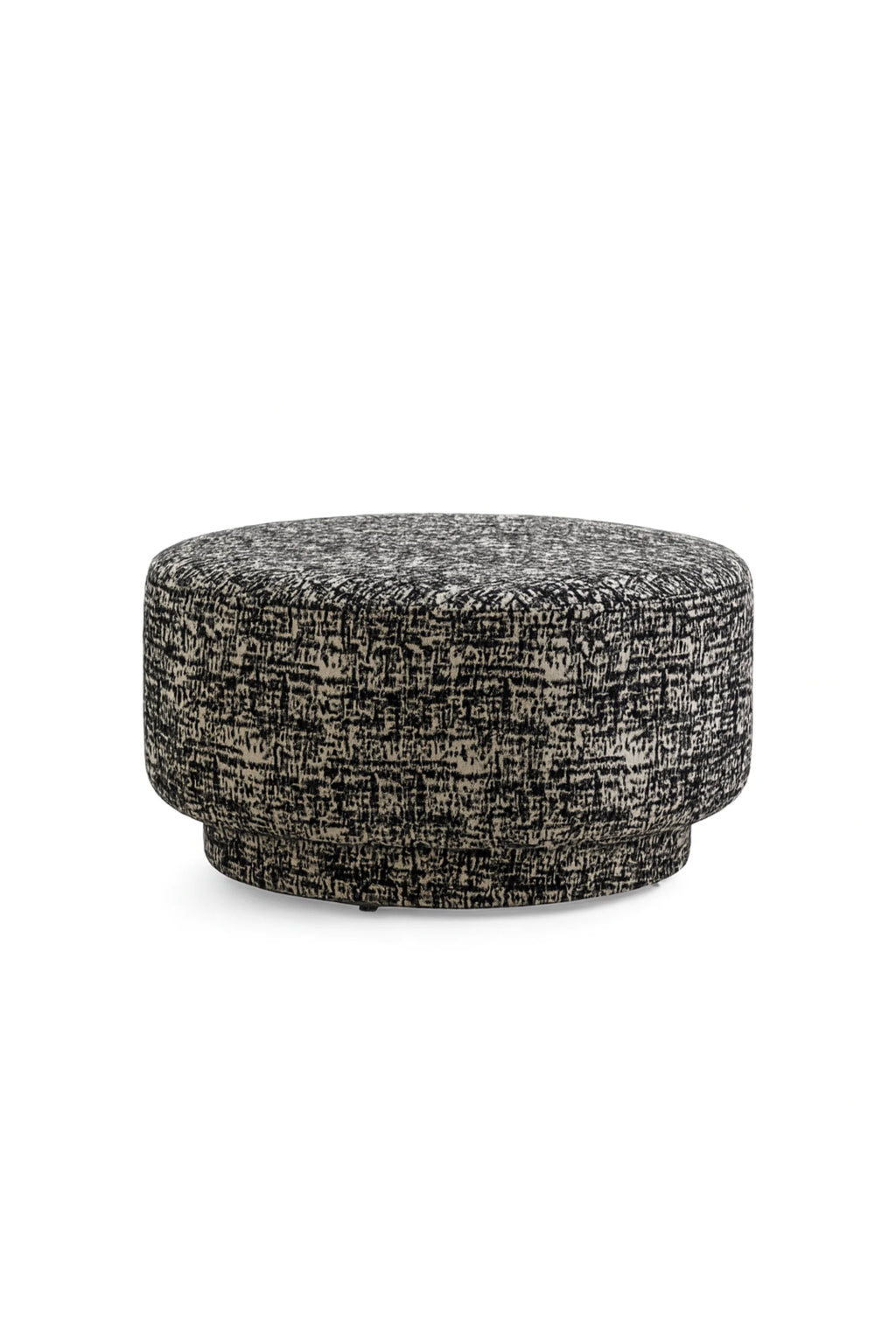 Nordal Bomu Pouf, a round contemporary pouf upholstered in a textured black and cream fabric featuring a dynamic abstract pattern and a subtle two-tiered cylindrical shape. This modern upholstered ottoman is perfect as an accent stool or footrest for stylish living rooms, bedrooms, or cozy reading nooks.