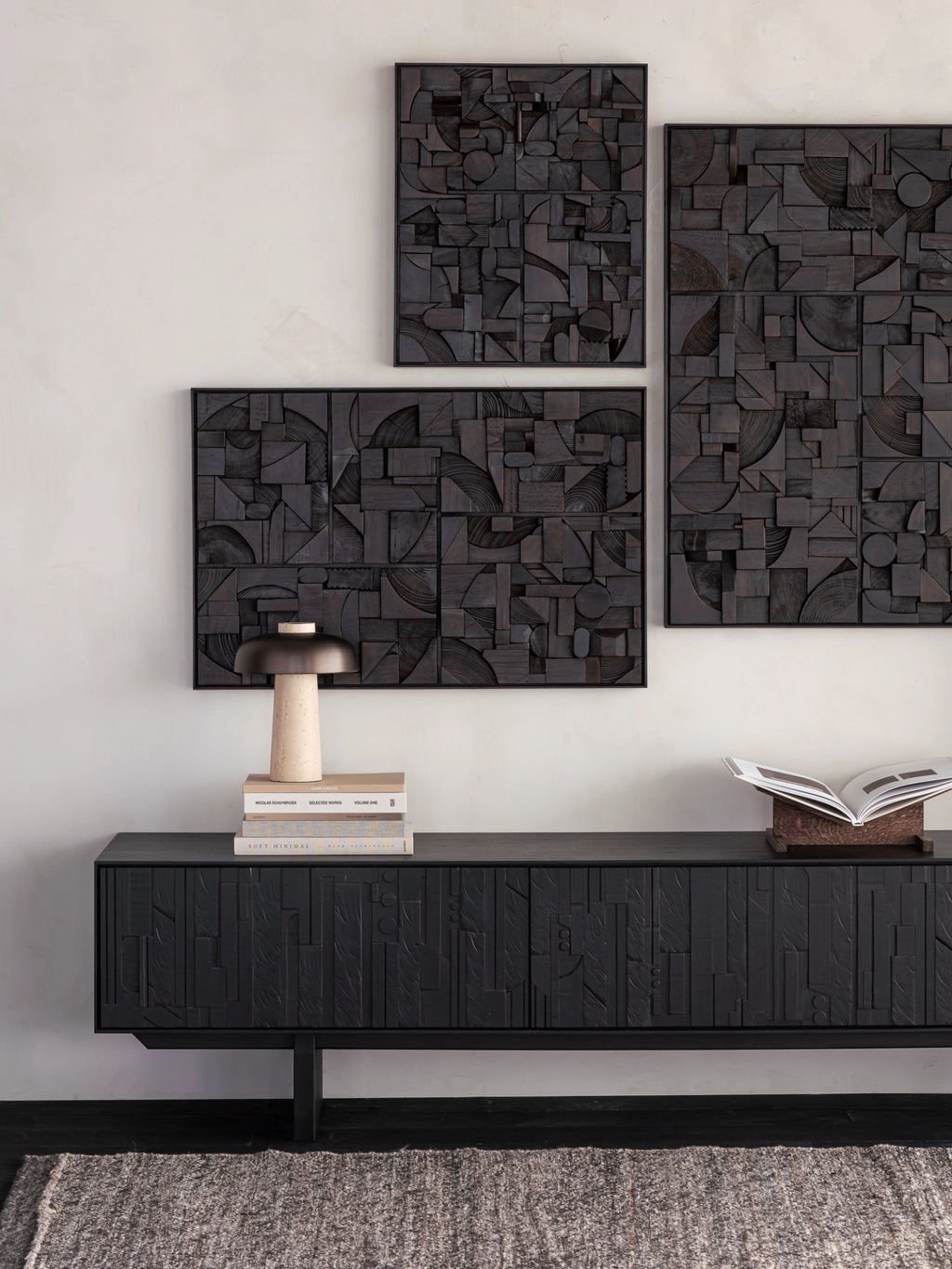 Ethnicraft Bricks Wall Art, a captivating abstract geometric dark wood wall art panel, handcrafted from numerous varied wood pieces in deep charcoal and black tones. It features a rich, textured relief of squares, rectangles, and curved shapes, creating an intricate three-dimensional design. Perfect for a modern minimalist living room, brutalist inspired interior, or as a bold statement piece in a contemporary entryway.