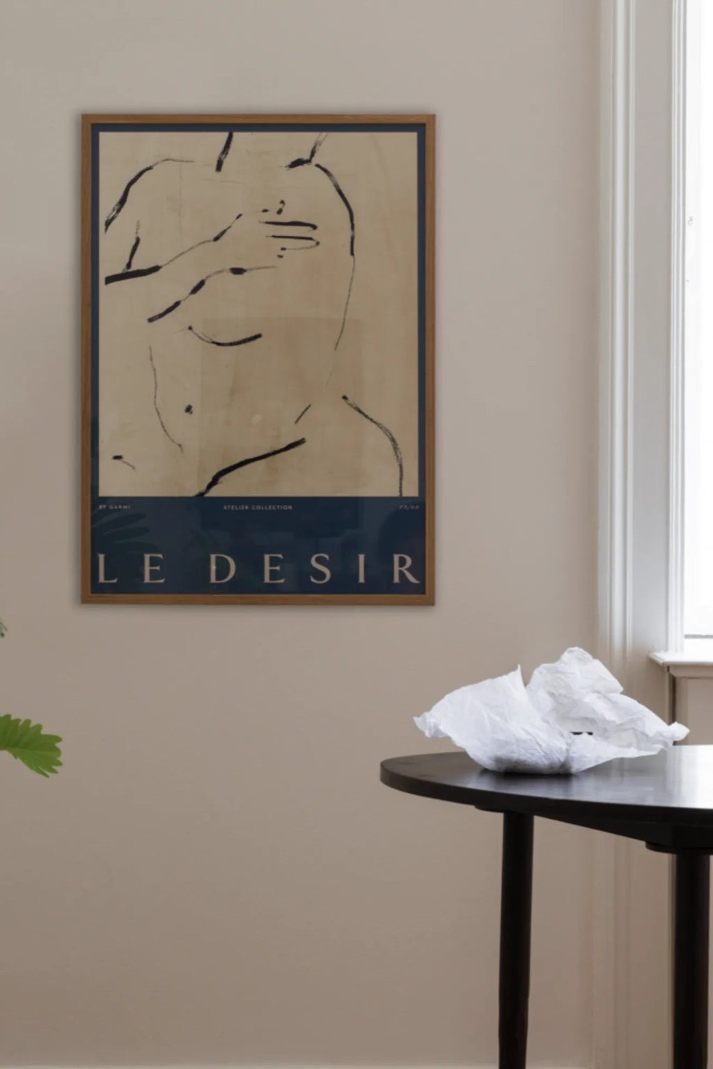 The Poster Club Le Desir, an abstract figurative line art print by Garmi featuring minimalist black brushstroke outlines of a body against a warm beige background, with a deep navy blue block at the bottom displaying 'LE DESIR' in white text. This contemporary art poster is housed in a natural oak frame, perfect as modern wall art for a gallery wall, living room, or minimalist bedroom decor.