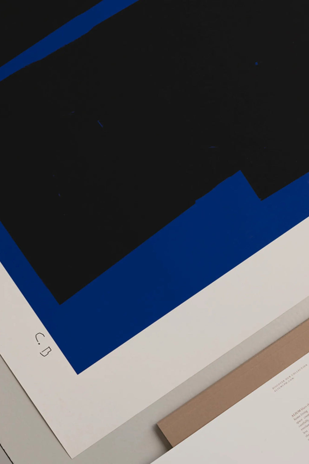 The Poster Club Blue Geometric 02, a bold abstract art print featuring graphic black geometric shapes with subtly textured edges against a vibrant royal blue background, bordered by crisp white paper and signed "C.
