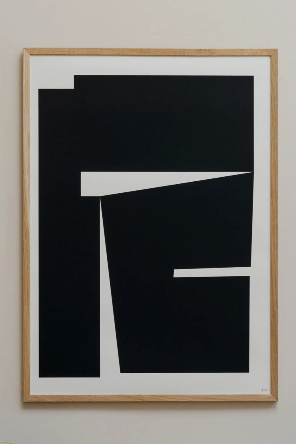 The Poster Club Composition 04, a striking minimalist abstract art print featuring bold black geometric shapes and crisp white negative space, creating a dynamic visual composition. This contemporary wall art is presented in a natural solid oak frame, enhancing its modern aesthetic. Perfect for creating a sophisticated focal point in a modern living room, bedroom, or as part of a curated gallery wall in minimalist or Scandinavian-inspired spaces.