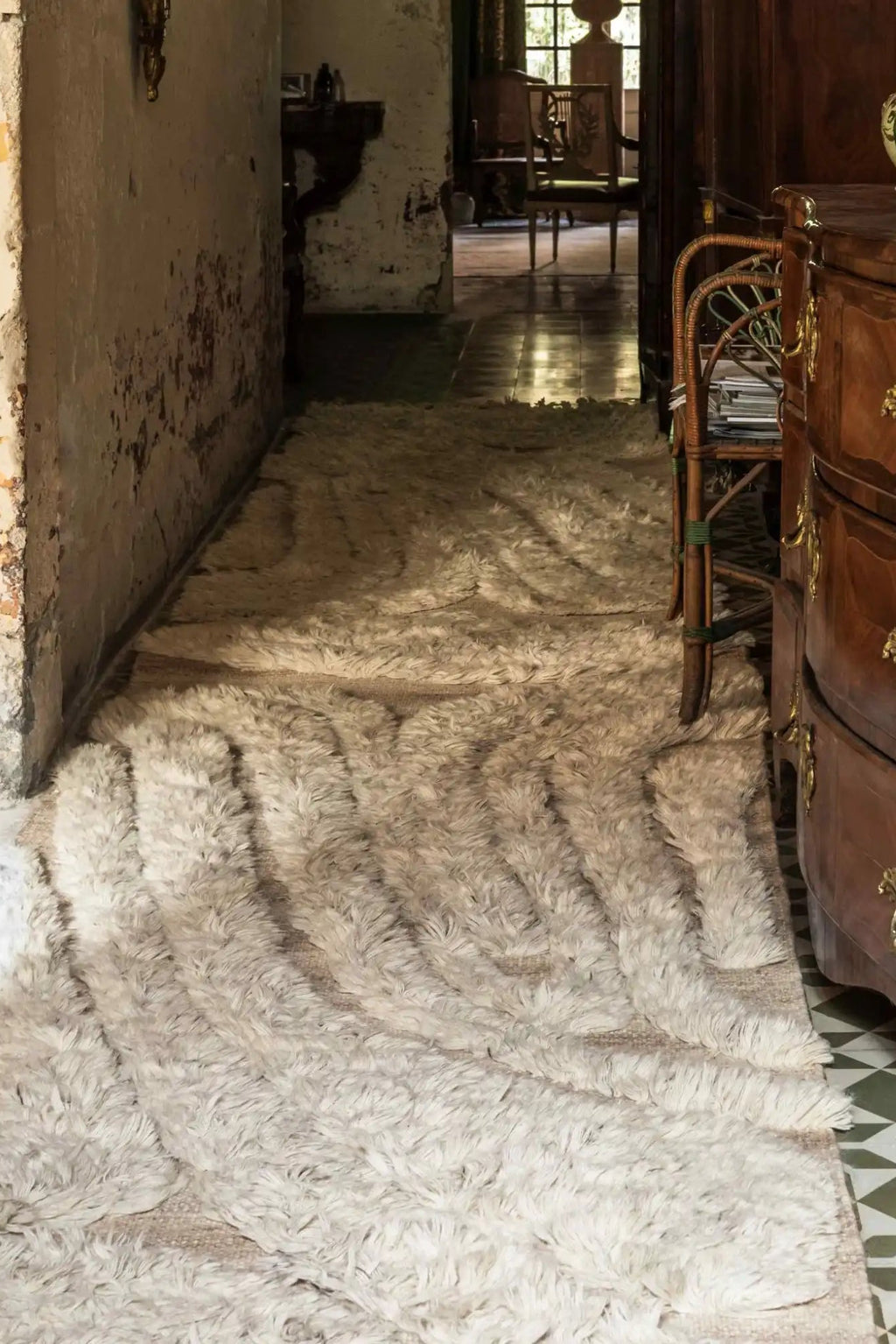 Cappelen Dimyr Colonnade No.01 Rug, a luxurious hand-knotted wool rug in a natural cream and off-white color, featuring an exceptionally high shaggy pile and distinctive wavy textured pattern. This plush natural wool rug offers an organic modern feel, perfect for adding warmth and sophisticated style to a minimalist living room, cozy bedroom, or elegant hallway.
