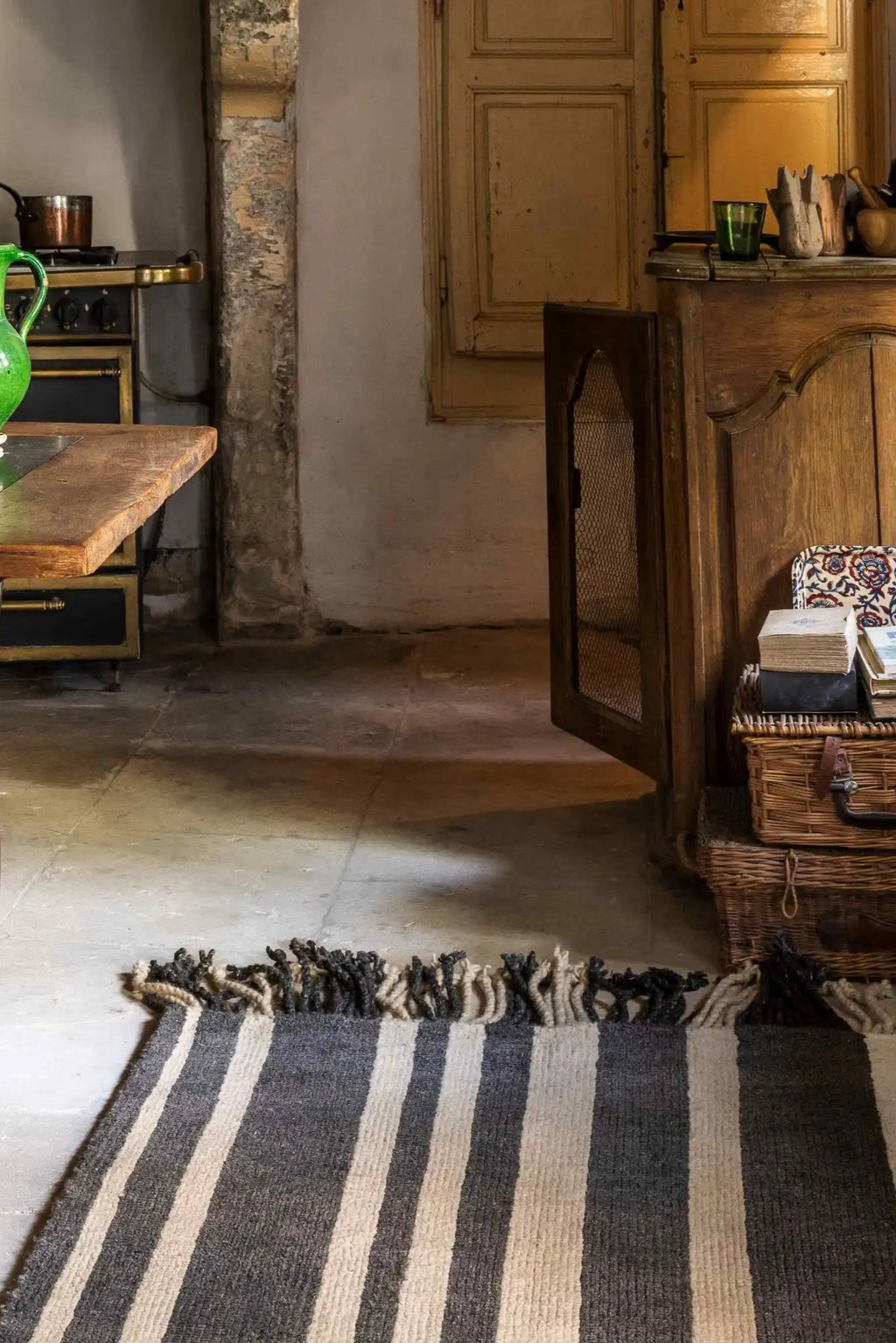 Cappelen Dimyr Colonnade No.05 Rug, a hand-knotted wool area rug featuring bold vertical stripes in natural cream and dark charcoal grey, with a plush shaggy texture and playful fringe detailing on the ends. This rustic bohemian rug is perfect for adding warmth and organic modern style to living rooms, bedrooms, or entryways.