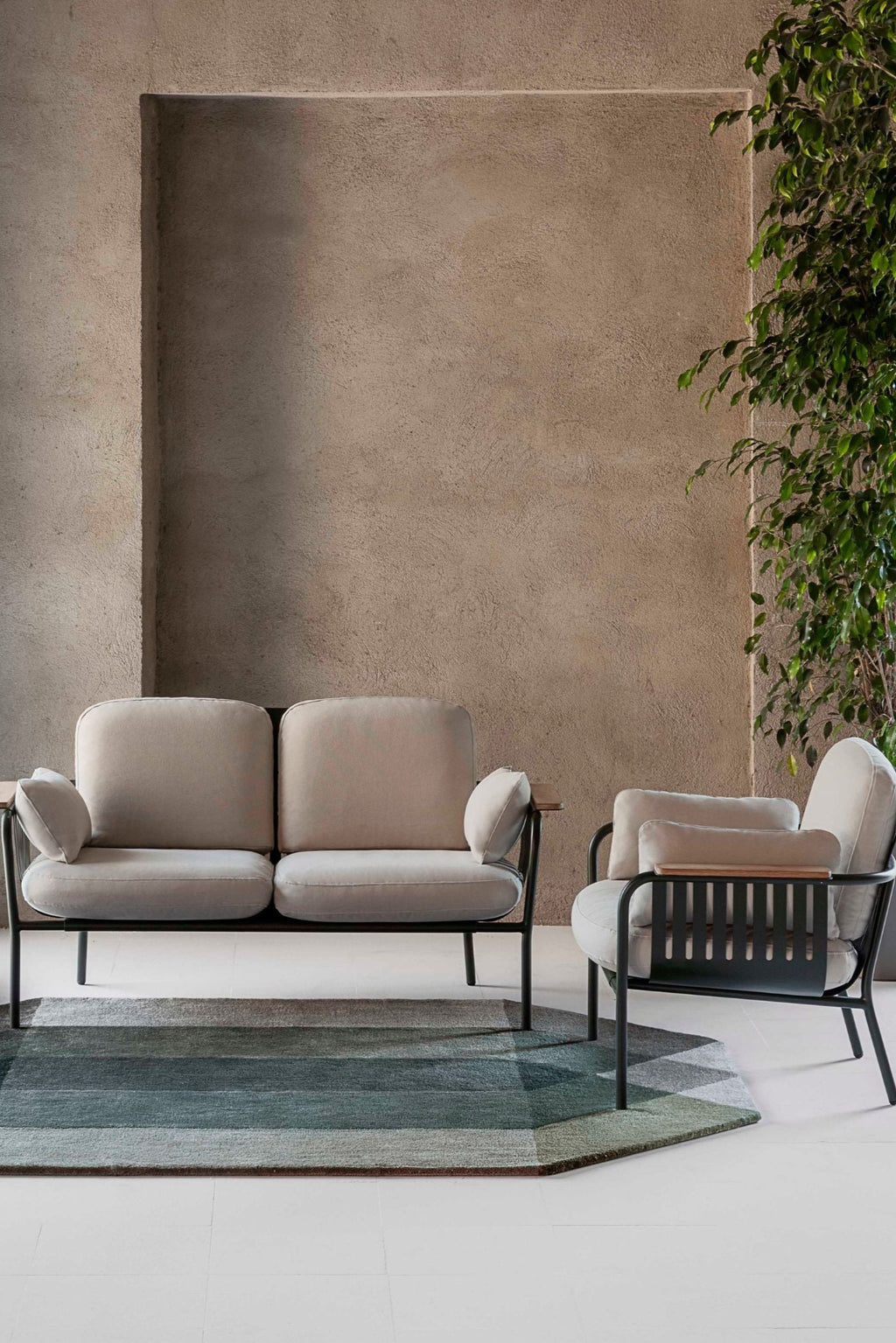 Gandia Blasco Capa 2-Seat Sofa, a modern outdoor sofa designed with a durable matte black metal frame, soft light beige fabric cushions, and elegant natural wood armrest accents. This contemporary 2-seater provides comfortable and stylish seating, perfect for a minimalist patio, garden, or outdoor lounge area.