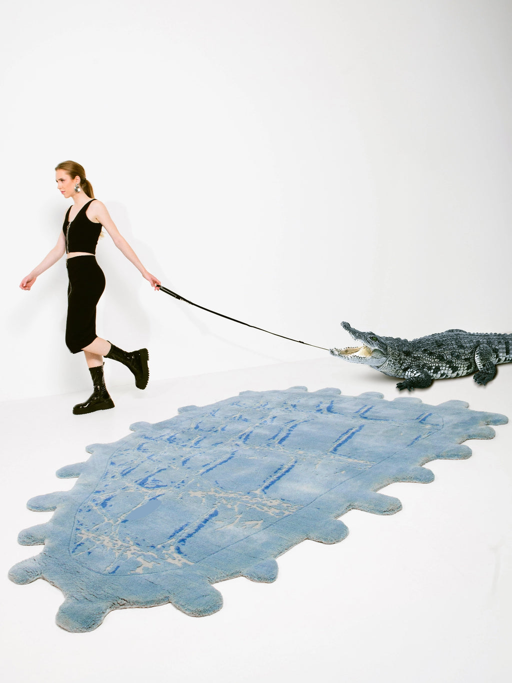Haus Üger Crocodile Rug, a unique hand-tufted wool area rug in soft pale blue with an organic, irregular silhouette and scalloped edges, featuring a textured surface with mottled darker blue and cream patterns.