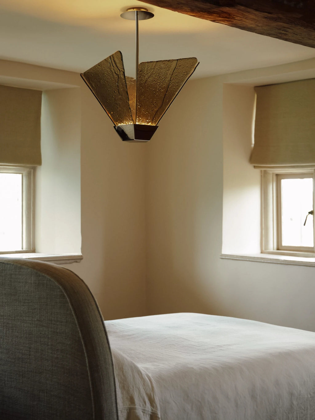 CTO Lighting Shard Pendant Light, a luxurious and sculptural ceiling light featuring multiple triangular panels of heavily textured, artisanal amber glass that radiate from a dark bronze metal base.