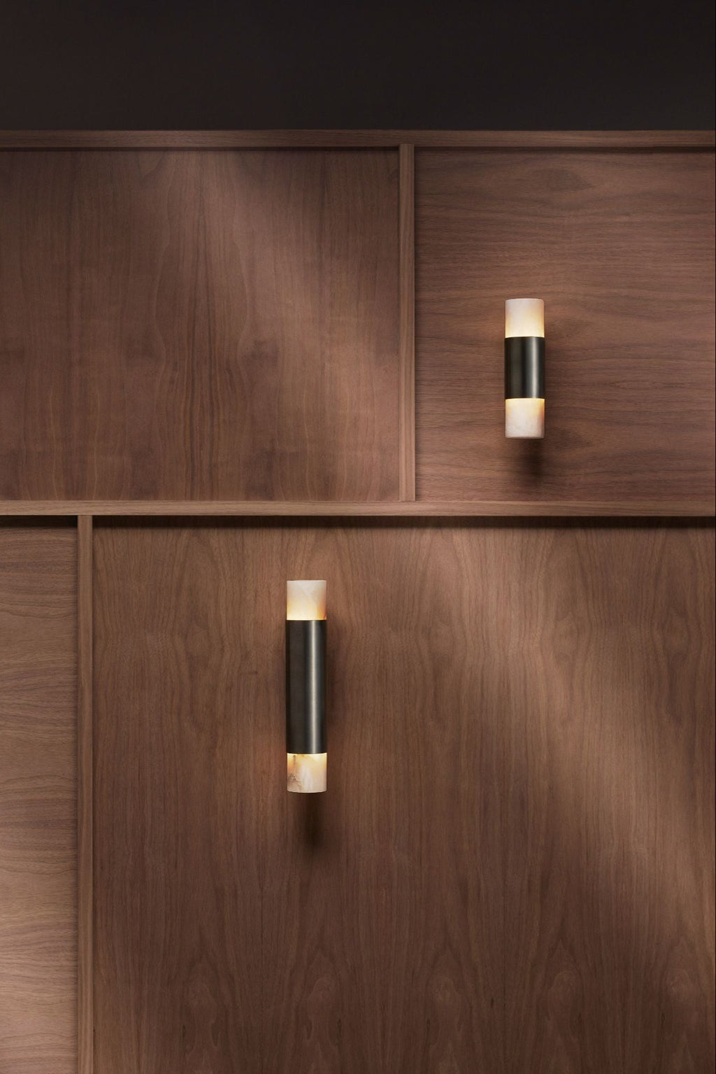 CTO Lighting Roma Wall Lamp, a sleek modern minimalist wall light featuring a matte black metal central band flanked by natural alabaster diffusers that emit a warm up and down ambient glow. This luxury cylindrical wall sconce offers sophisticated architectural lighting for contemporary living rooms, elegant bedrooms, or stylish hallways.