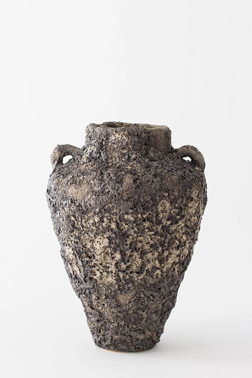 Canoa Lab Arq 001 Vase, a striking, modern ceramic vase with a dark, volcanic-like textured finish and two small handles, creating a unique, rustic aesthetic, displayed on a white background.