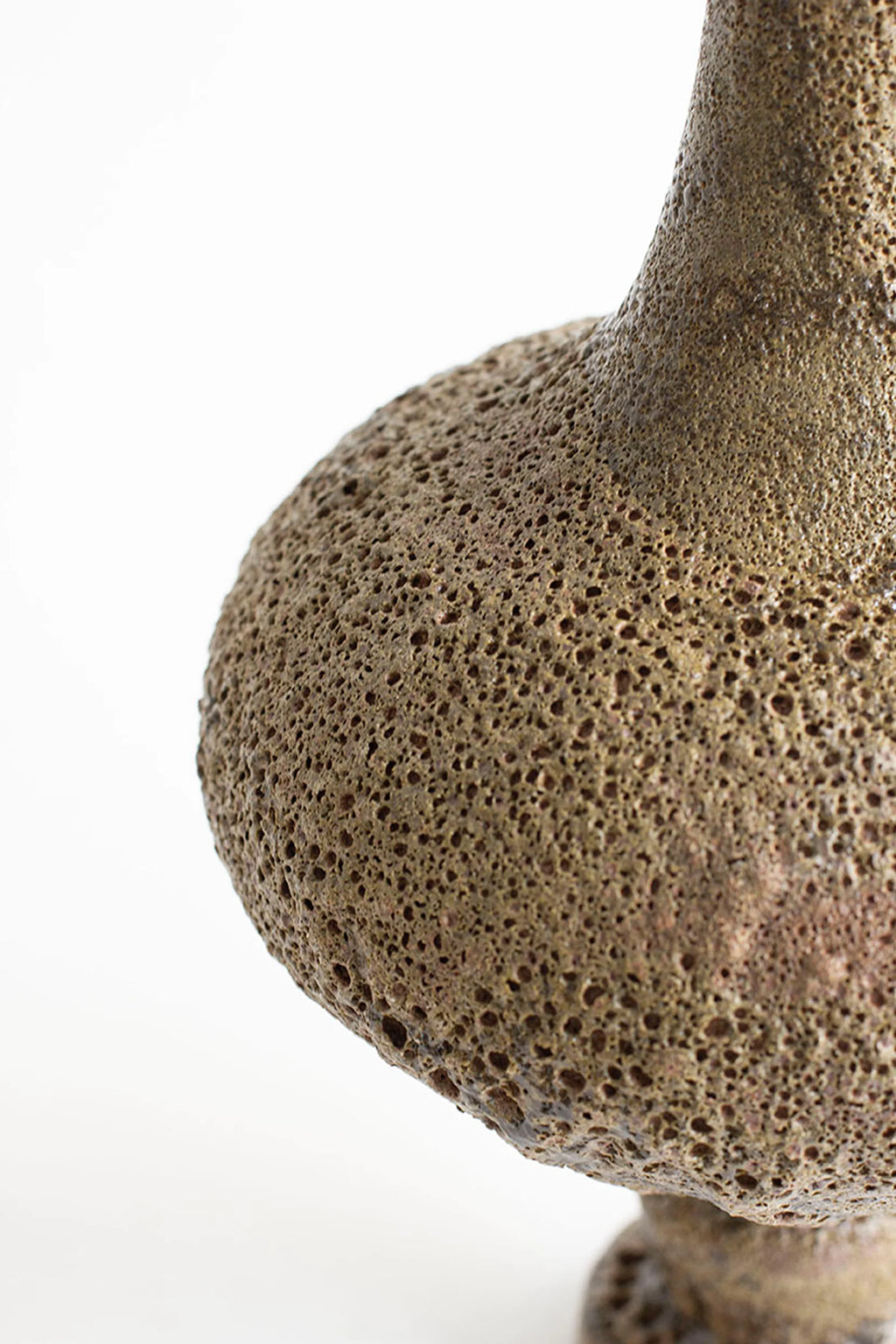 Canoa Lab Arq 002 Musgo Vase, a handcrafted ceramic vase featuring a rich musgo (moss green/brown) color and an intensely textured, porous volcanic finish. This sculptural stoneware piece, with its organic silhouette and raw, earthy aesthetic, is perfect for adding a wabi-sabi touch to organic modern interiors or minimalist shelf styling.