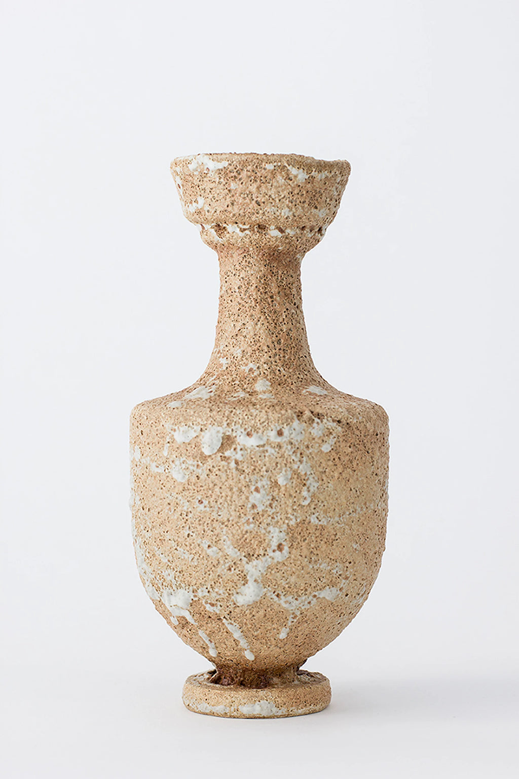 Canoa Lab Arq 003 Vase, a handcrafted ceramic vase featuring a unique porous, sandy texture in earthy beige tones with a rustic white distressed finish. Its distinctive organic modern silhouette showcases a flared rim, narrow neck, and a wider, rounded body resting on a subtle circular base. This artisanal stoneware vase is perfect for wabi-sabi or brutalist home decor, ideal for minimalist shelf styling in living rooms or entryways.