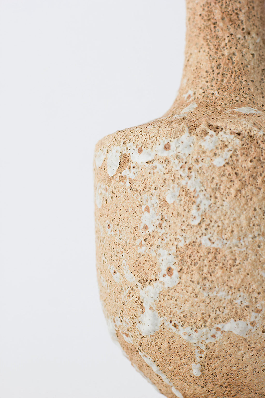 Canoa Lab Arq 003 Vase, a handcrafted ceramic vase with a highly textured, porous volcanic finish in warm sandy beige and light brown tones, accented with organic streaks of creamy white glaze.