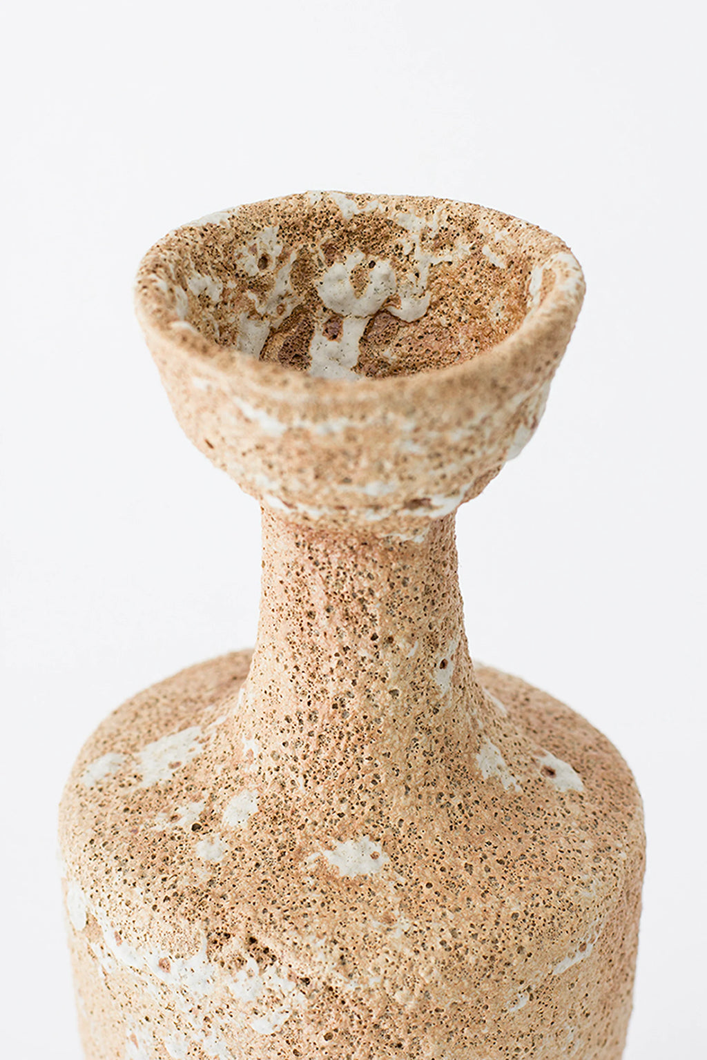 Canoa Lab Arq 003 Vase, a handcrafted ceramic vase featuring a unique porous, volcanic texture in warm earthy beige and sand tones with irregular white accents.