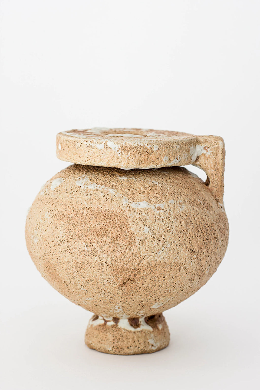 Canoa Lab Arq 004 Vase, a modern, rounded ceramic vase with a lid and handle, featuring a textured, earthy beige and white finish, displayed on a clean white background.