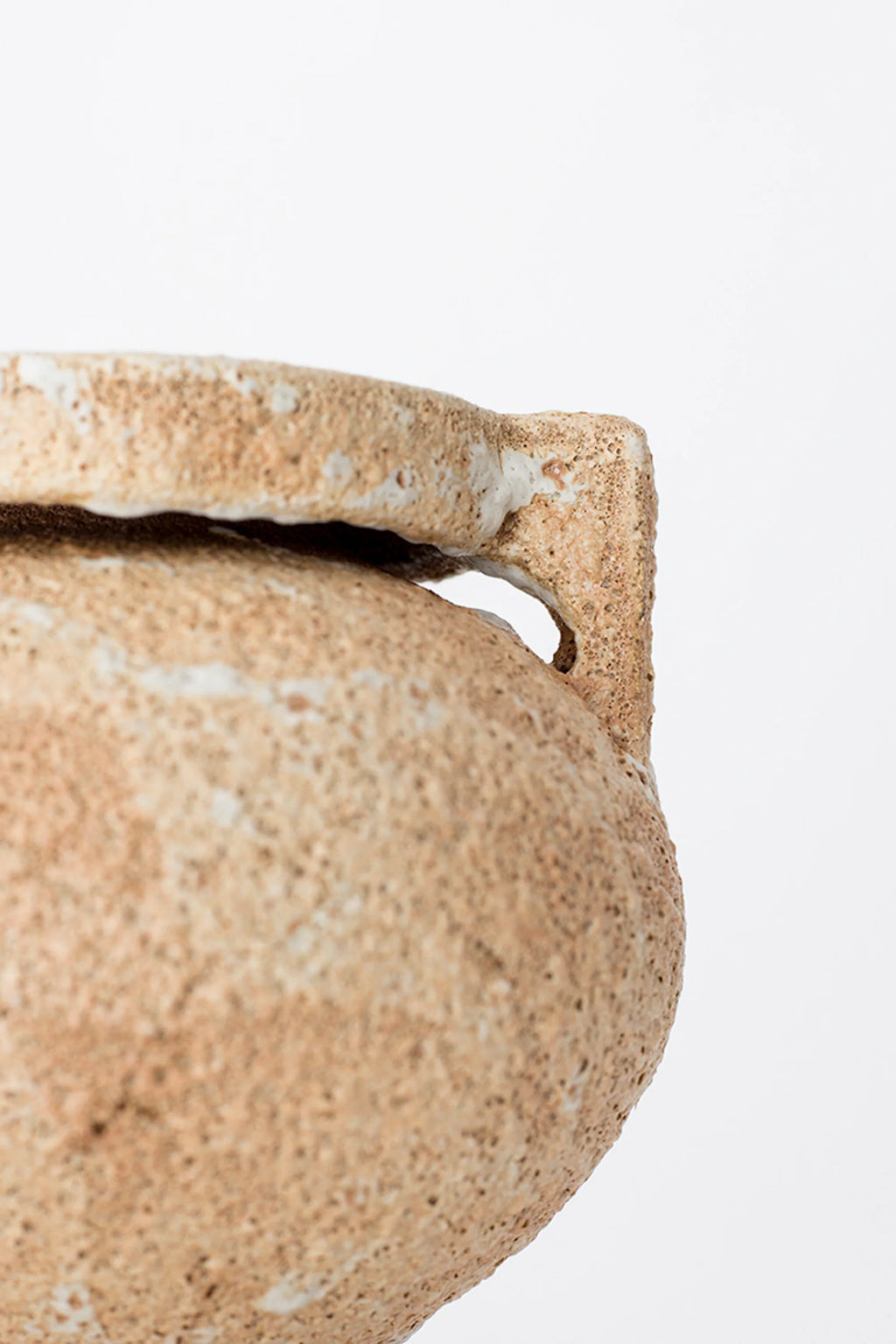 Canoa Lab Arq 004 Vase, a close-up of the modern ceramic vase's textured handle and side, showcasing its earthy beige and white porous finish, displayed on a clean white background.