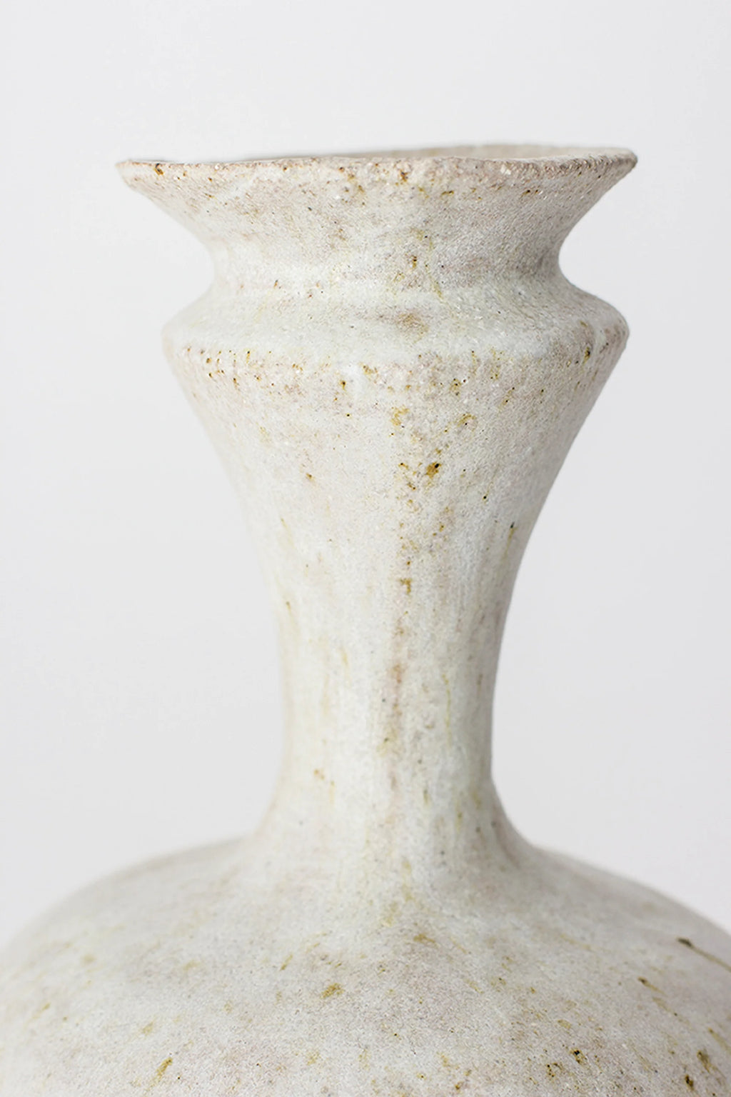 Canoa Lab Arq 006 Vase, a close-up of the slender, fluted neck and upper body of the elegant ceramic vase. The speckled off-white finish with subtle earthy tones highlights the artisanal texture and refined, modern design. Displayed on a clean white background.