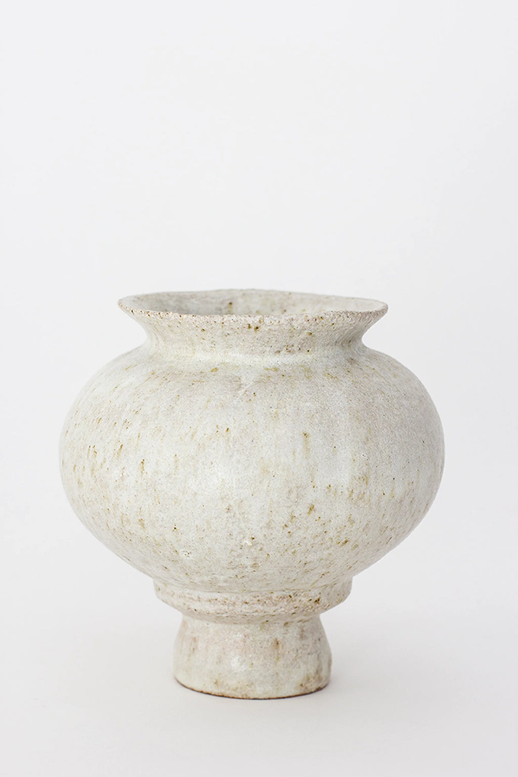 Canoa Lab Arq 007 Vase, a charming, rounded ceramic vase in a speckled, off-white finish, featuring a wide mouth and a subtle pedestal base, exuding a handcrafted, organic aesthetic on a white background.