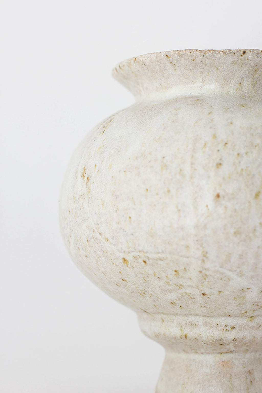 Canoa Lab Arq 007 Vase, a modern, bulbous ceramic vase in a speckled off-white finish with subtle earthy tones, displayed on a clean white background. The elegant design features a narrow, fluted neck and a wide, rounded body, showcasing its unique handcrafted texture.