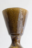 Brown ceramic cup with a textured surface on a white background