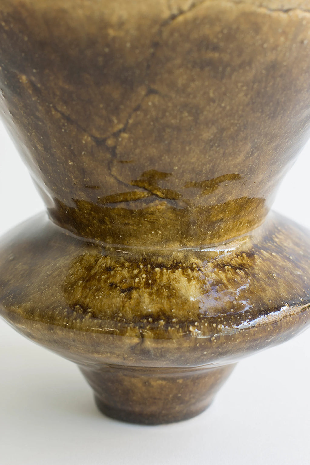 Canoa Lab Arq 010 Vase, a close-up of the handcrafted ceramic vase highlighting its glossy dark brown glaze with intricate crackle patterns and textured surface, displayed on a white background.