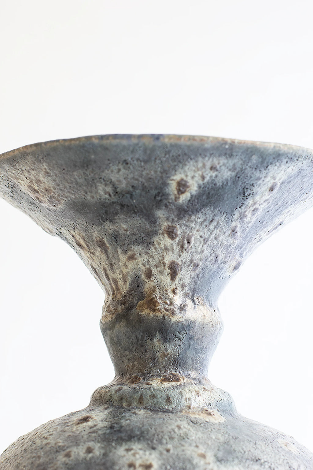 Canoa Lab Ánfora Gecko Vase, a handcrafted stoneware ceramic vase featuring a distinctive mottled dark grey and ash finish with a rough, porous, volcanic texture, showcasing an organic amphora-like.