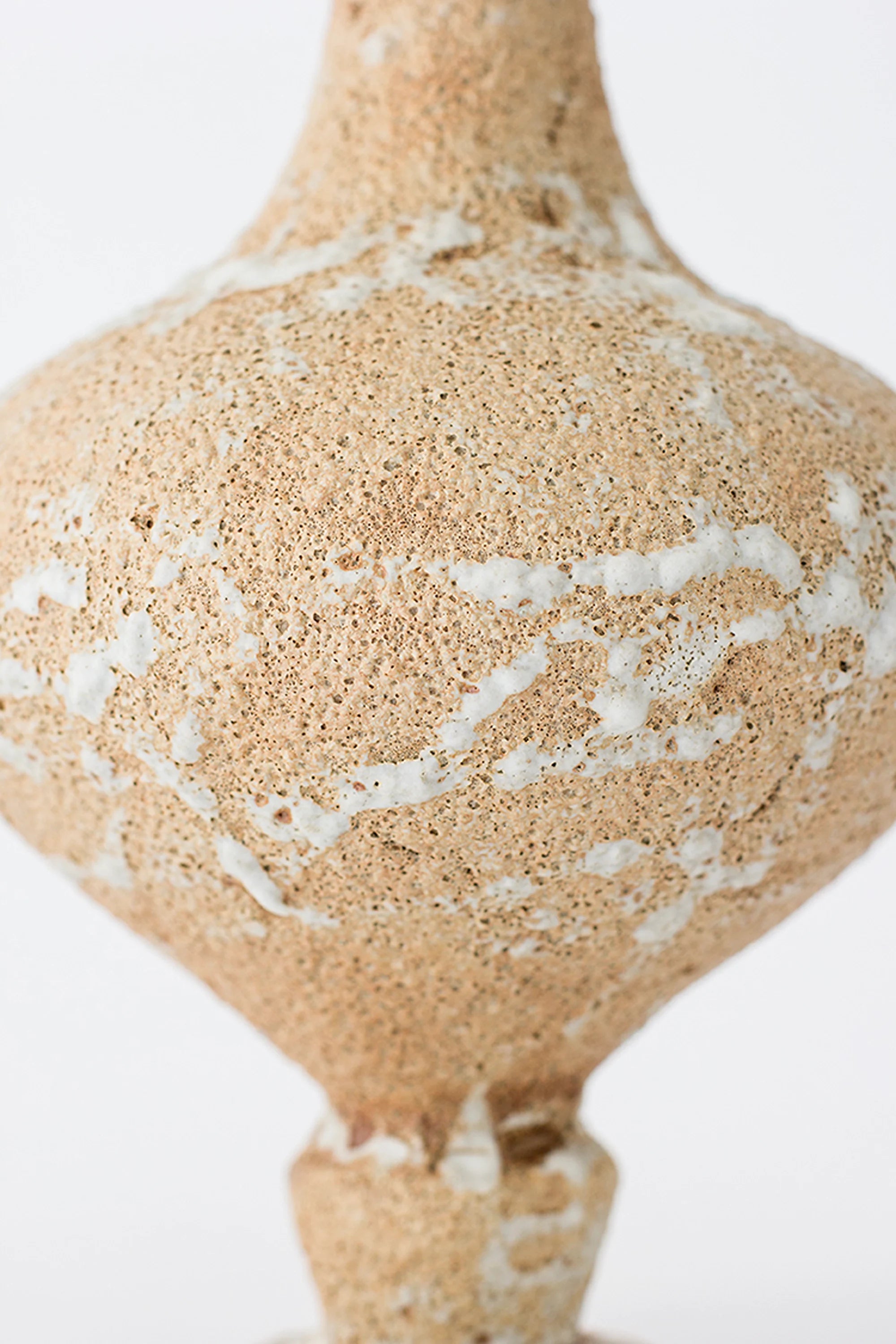 Beige ceramic vase with white marbled pattern on a white background