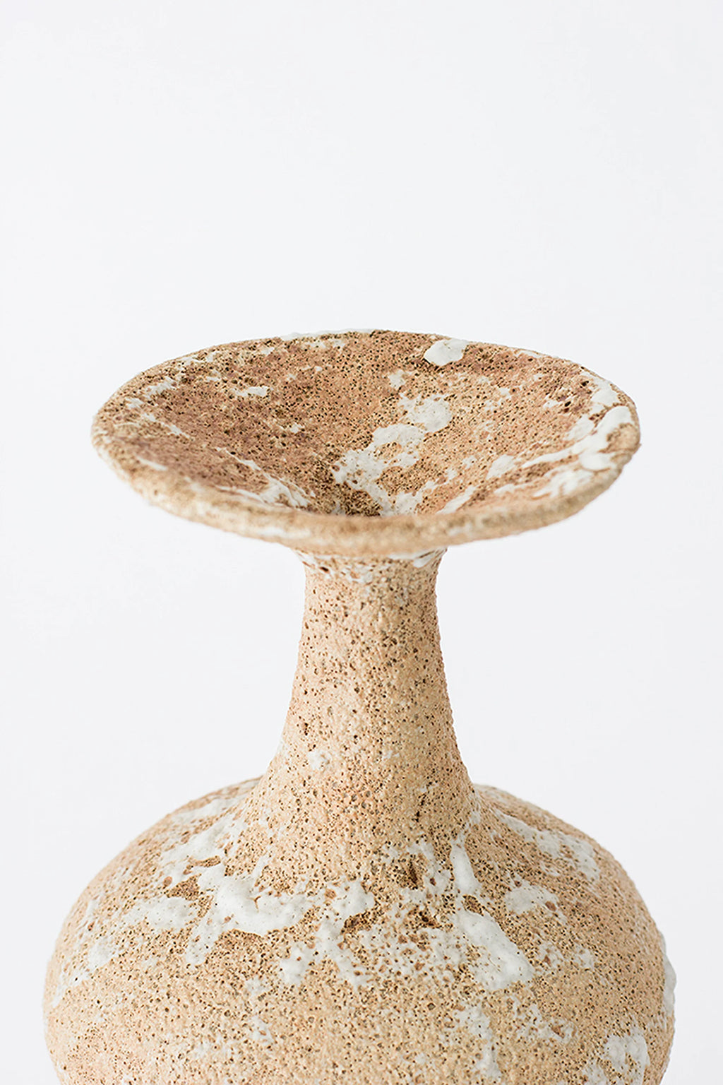 Canoa Lab Arq 002 Vase, a handcrafted ceramic vase with a unique sculptural form, featuring a porous, volcanic-like texture in earthy beige and tan tones with natural white glaze accents. This organic modern stoneware piece showcases a flared stem and a wide, shallow dish opening, making it perfect for minimalist shelf styling or as a wabi-sabi inspired decorative object in contemporary living rooms and entryways.