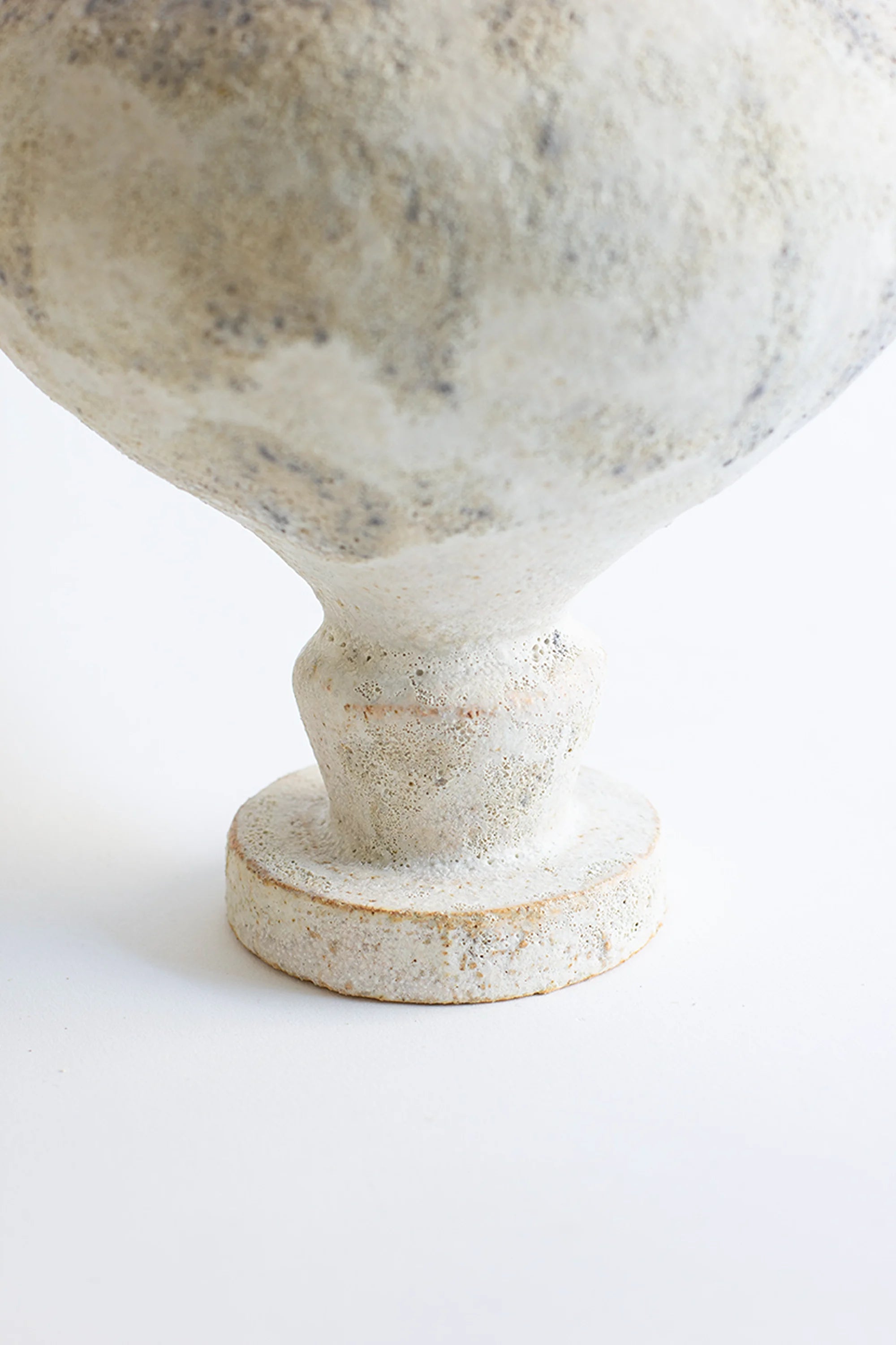 Close-up of a textured white vase on a light background