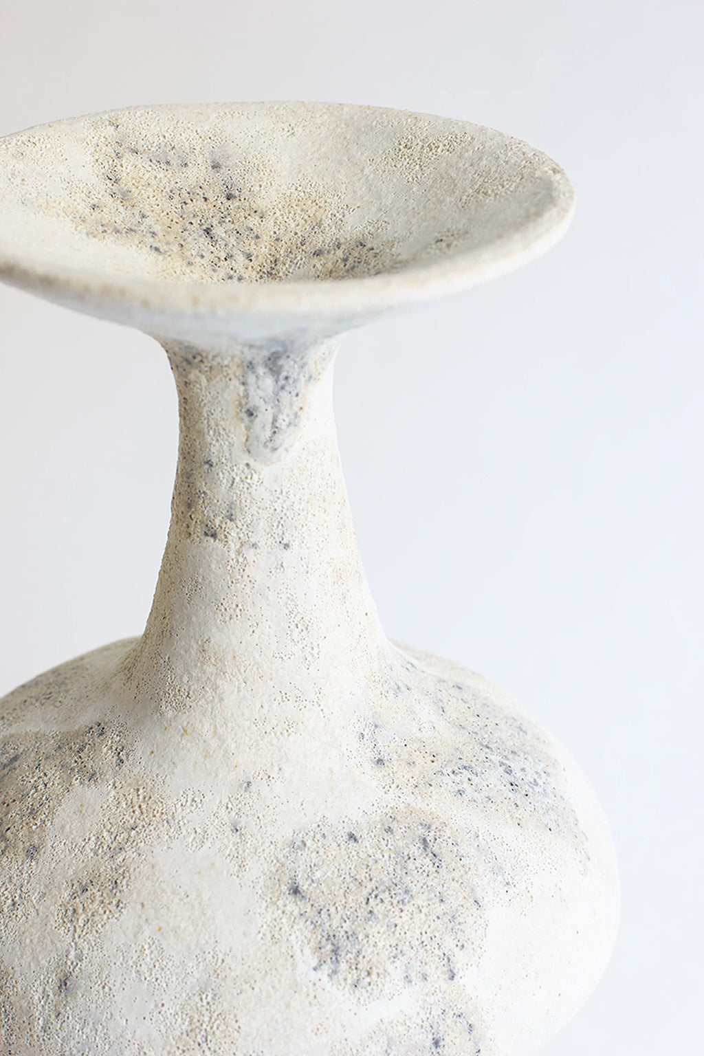 Canoa Lab Arq 002 Cárabo Vase, a handcrafted stoneware vase in natural cream and off-white tones, featuring a deeply textured, porous, and organic finish.